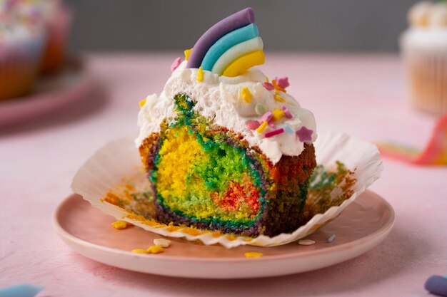 Der köstliche Regenbogen-Cupcake ist ein Stillleben.
