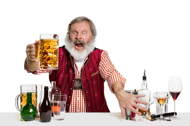 Der männliche Barkeeper des leitenden Experten mit Bier im Studio lokalisiert auf weißem Hintergrund. Internationaler Barmann-Tag, Bar, Alkohol, Restaurant, Bier, Party, Kneipe, St. Patrick's Day-Feierkonzept