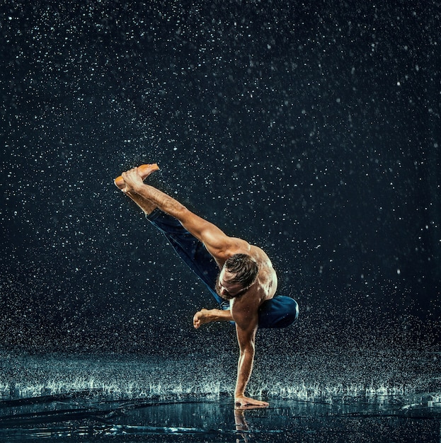 Der männliche Breakdancer im Wasser.