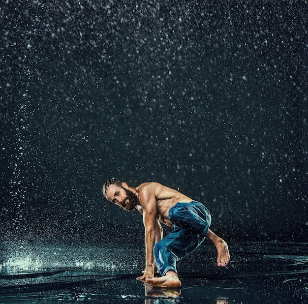 Der männliche Breakdancer im Wasser.