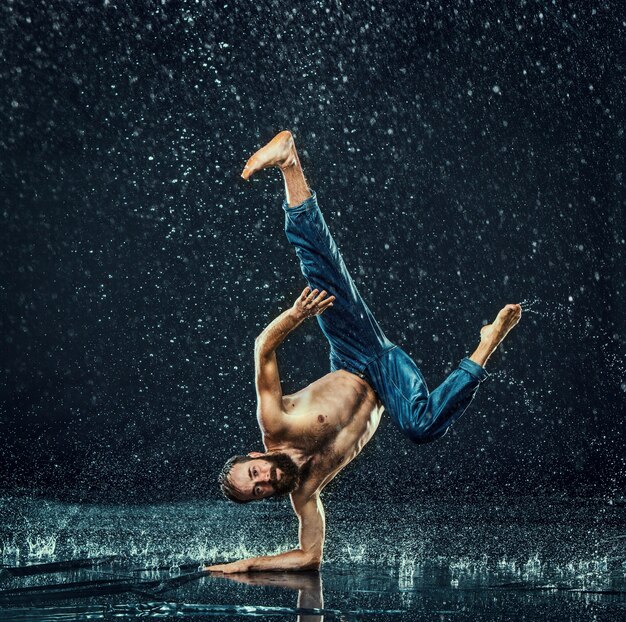 Der männliche Breakdancer im Wasser.