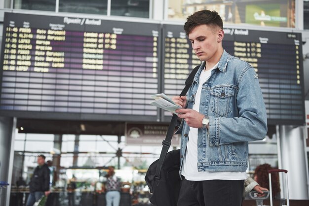 Der Mann erwartet seinen Flug am Flughafen.