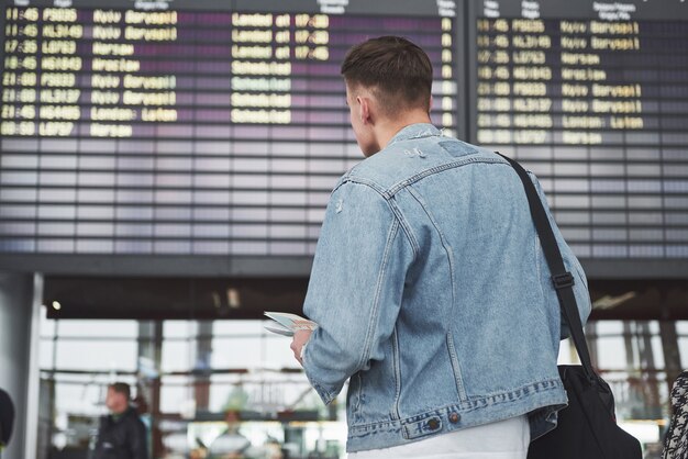 Der Mann erwartet seinen Flug am Flughafen.