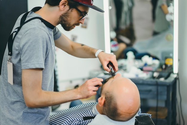 der Mann im Friseursalon. Der Bart rasiert sich