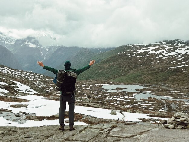 Der Mann mit einem Rucksack bewundert herrliche Berglandschaft