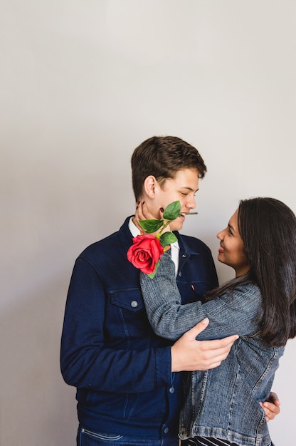 Der Mann mit einer Rose in seinem Mund und seine Freundin zu berühren sein Gesicht