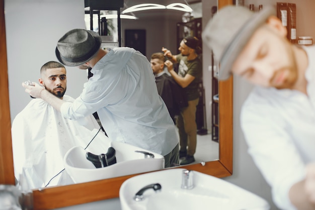 Der Mann schneidet seinen Bart in den Friseursalon.