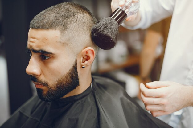 Der Mann schneidet seinen Bart in den Friseursalon.