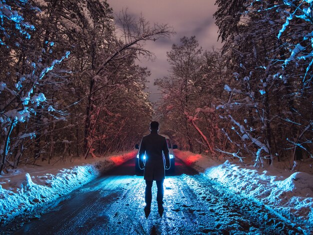 Der mann mit einer taschenlampe inspiziert die straße. abend nachtzeit