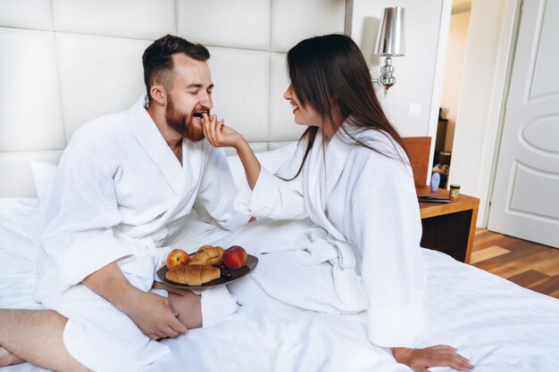 Der Mann und das Mädchen Bademantel, füttert Mädchen den Mann Obst