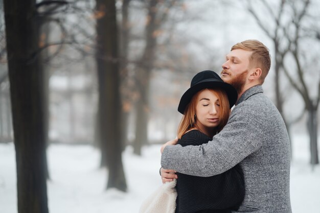 Der Mann und das Mädchen ruhen sich im Winterwald aus.