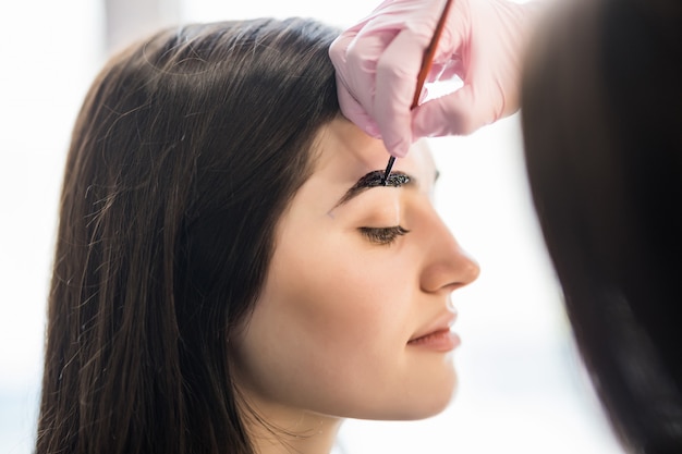 Der Meister hat die Augenbrauen der Models im Schönheitssalon mit schwarzer Farbe bemalt