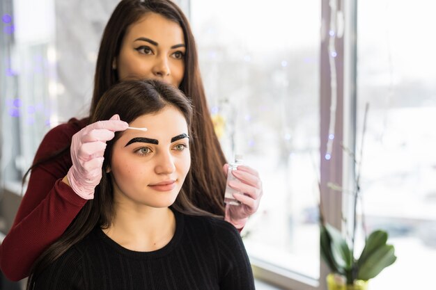 Der Meister trug die letzte Schicht schwarzer Farbe auf die Augenbrauen der Models auf