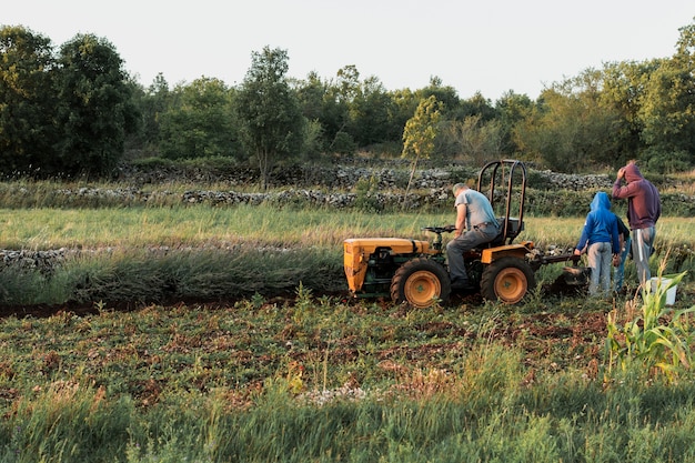 Kostenloses Foto der mensch und seine söhne kultivieren die ernte