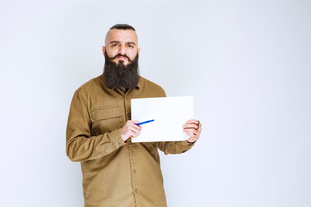 Der Projektleiter zeigt seinem Kollegen die Berichte und markiert die Fehler oder Korrekturen.