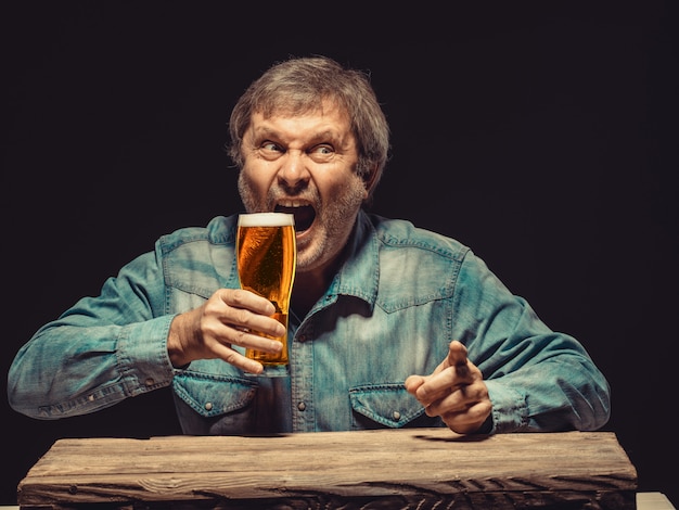 Kostenloses Foto der schreiende mann im jeanshemd mit einem glas bier