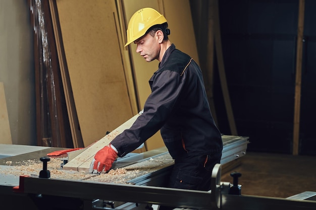 Kostenloses Foto der schreiner lehnt am holztisch.