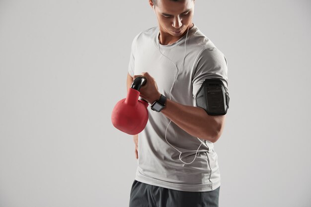 Der Sportler, der Bizeps tut, trainieren mit kettlebell