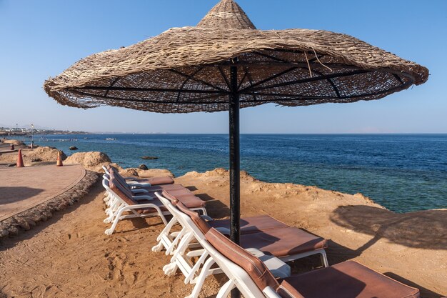 Der Strand im Luxushotel Sharm el Sheikh, Ägypten. Regenschirm gegen den blauen Himmel