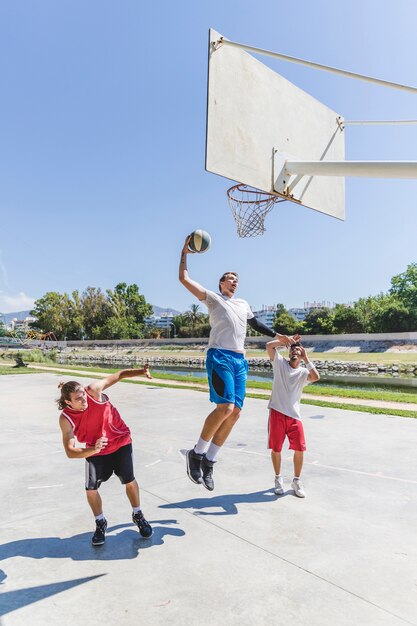 Der Straßenbasketballathlet, der enormen Knall durchführt, tauchen auf das Gericht ein