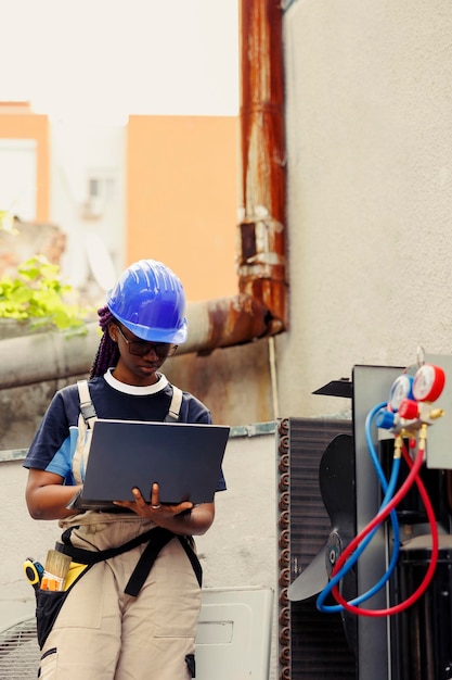 Der Techniker wurde mit der routinemäßigen fachmännischen Wartung beauftragt, um kostspielige Wartungsarbeiten zu vermeiden und die Langlebigkeit der Klimaanlagen sicherzustellen. Zertifizierter Techniker führt Klimaanlagensonde durch und gibt Daten auf Laptop ein