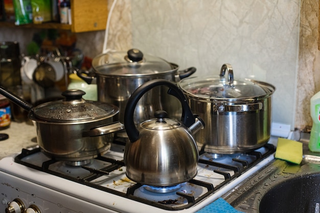 Der Wasserkocher und die Pfannen stehen auf dem Herd. Kochen in der Küche