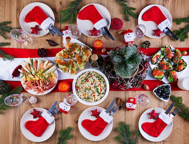 Der Weihnachtstisch wird mit einer Vorspeise serviert, die mit hellem Lametta und Kerzen dekoriert ist. Sitzordnung bei Tisch. Weihnachtsessen. Flach liegen. Draufsicht