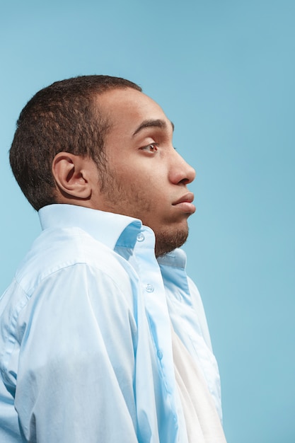 Der zweifelhafte afroamerikanische Mann schaut erschrocken gegen den blauen Raum