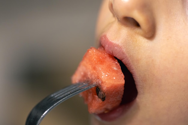 Kostenloses Foto detaillierte aufnahme eines mädchens, das in eine wassermelone beißt