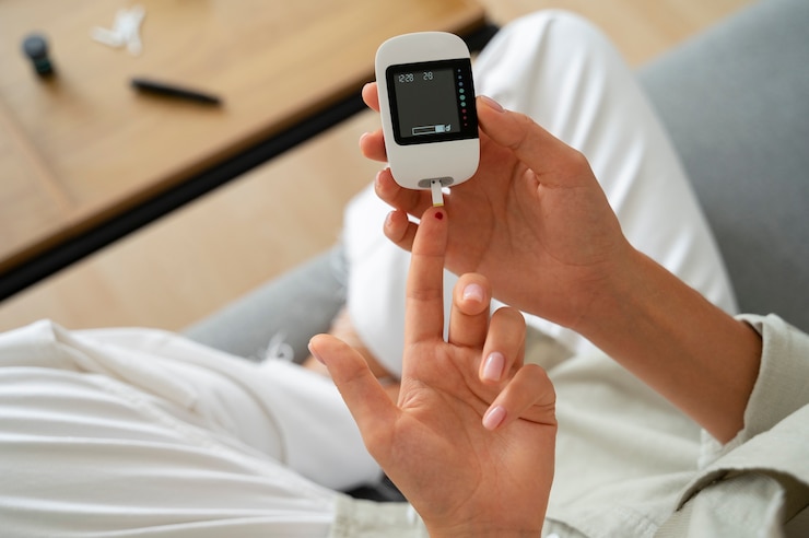 Kostenlose Foto diabetikerin von oben, die ihren glukosespiegel überprüft