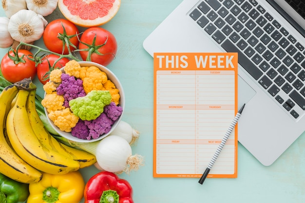 Diät-Wochenplan und gesundes Gemüse auf Hintergrund