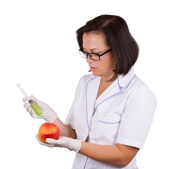Diätassistentin, ärztin, die frischen pfirsich hält, der mit spritze auf weiß auf weißem hintergrund injiziert wird