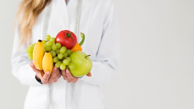 Diätkonzept mit weiblichem Wissenschaftler und gesundem Lebensmittel