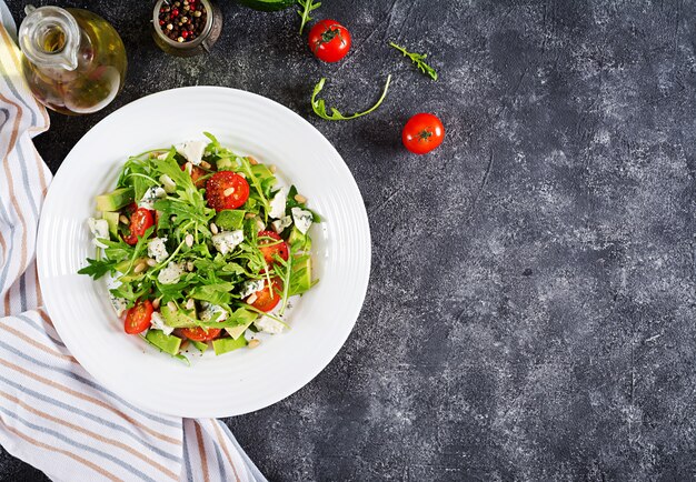 Diätsalat mit Tomaten, Blauschimmelkäse, Avocado, Rucola und Pinienkernen.