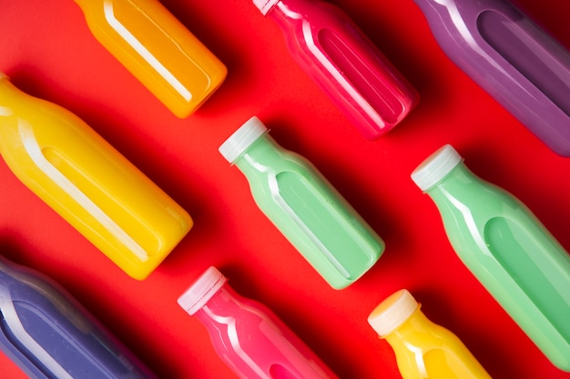 Diagonal bunte Smoothies auf rotem Hintergrund