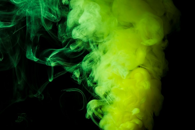 Dichte flaumige Hauche des grünen Rauches auf schwarzem Hintergrund