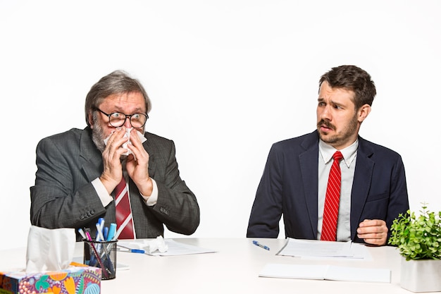 Die beiden Kollegen arbeiten im Büro auf Weiß zusammen.