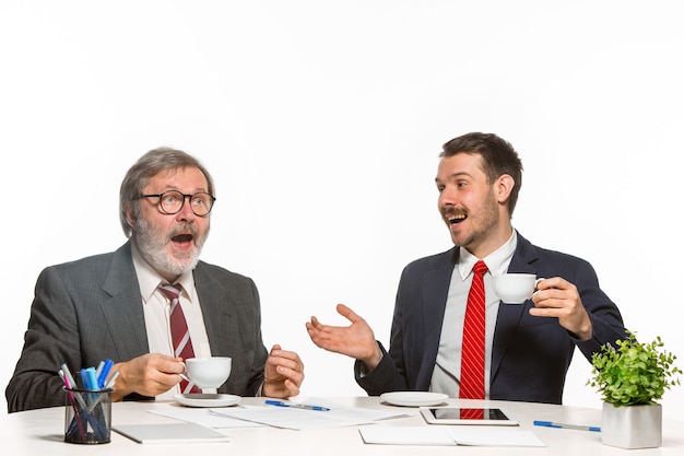 Die beiden Kollegen arbeiten im Büro auf Weiß zusammen.