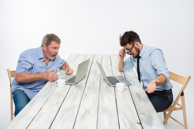 Die beiden Kollegen arbeiten zusammen im Büro an der weißen Wand