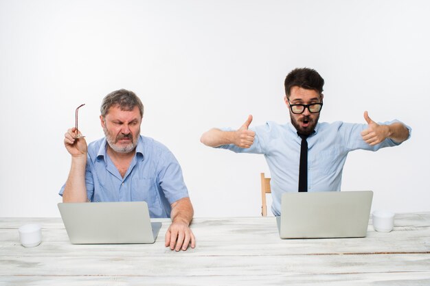 Die beiden Kollegen arbeiten zusammen im Büro an der weißen Wand