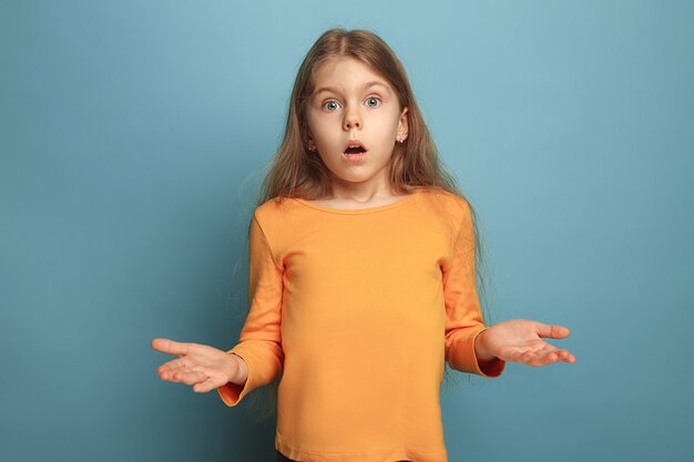 Die Überraschung, Freude. Das überraschte Teenager-Mädchen in einem blauen Studio