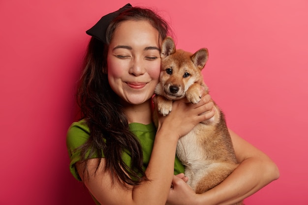 Die besten Freunde von Frau und Hund posieren zusammen vor der Kamera, umarmen sich mit Liebe, haben eine freundschaftliche Beziehung.