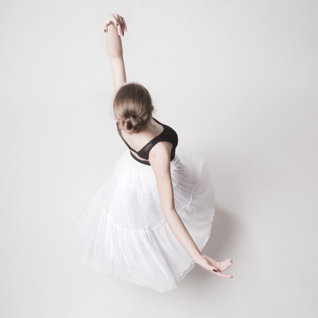 Die Draufsicht der jugendlich Ballerina auf weißem Studio