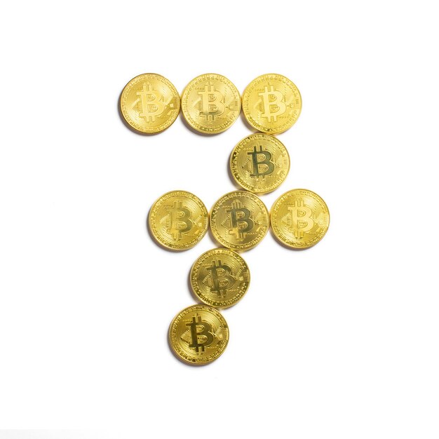 Die Figur von 7 aus Bitcoin-Münzen ausgelegt und auf weißem Hintergrund isoliert