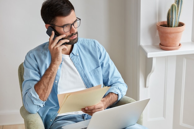 Die Fotografie eines ernsthaften Unternehmers erfährt von der Leistung seines Unternehmens, führt ein Telefongespräch mit dem Assistenten