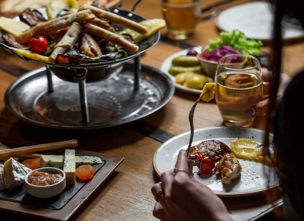 Die Frau, die Abendessen um den Tisch isst, spendete mit Lebensmittel