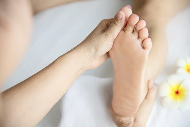 Die Frau, die Fußmassageservice vom nahem hohem der Masseuse und Fuß empfängt - entspannen Sie sich im Fußmassagetherapie-Servicekonzept