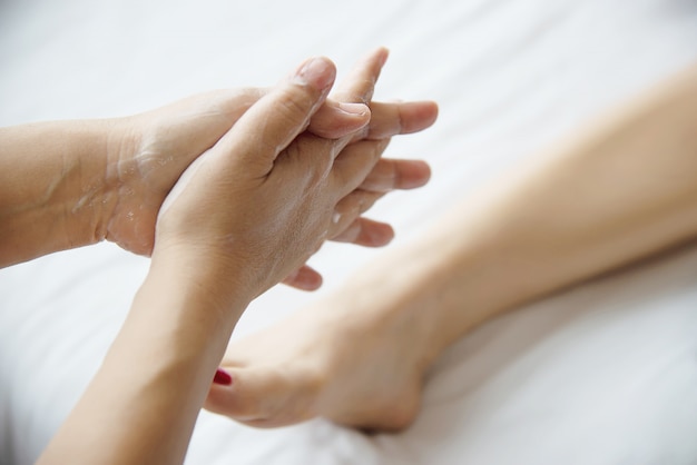 Die Frau, die Fußmassageservice vom nahem hohem der Masseuse und Fuß empfängt - entspannen Sie sich im Fußmassagetherapie-Servicekonzept