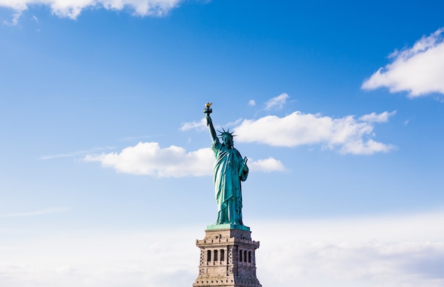 Die Freiheitsstatue mit bewölktem schönen Himmel