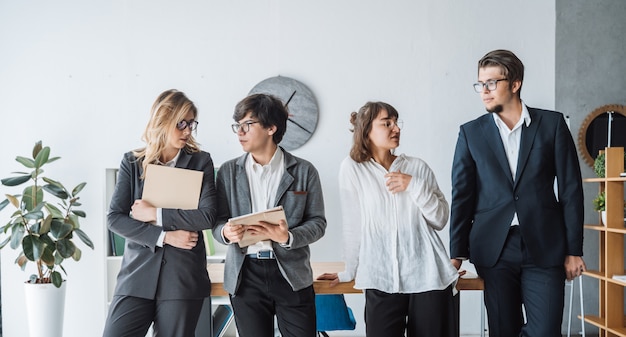 Die Geschäftsleute, die im Büro stehen, besprechen sich